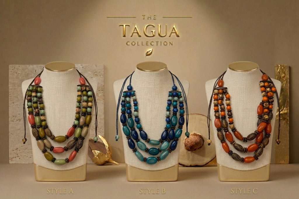 Three beaded necklaces displayed on cream fabric mannequin busts against a warm beige background, with the text 'THE TAGUA COLLECTION' above. The necklaces are labeled Style A, Style B, and Style C, featuring different bead combinations in green, red, blue, and orange.