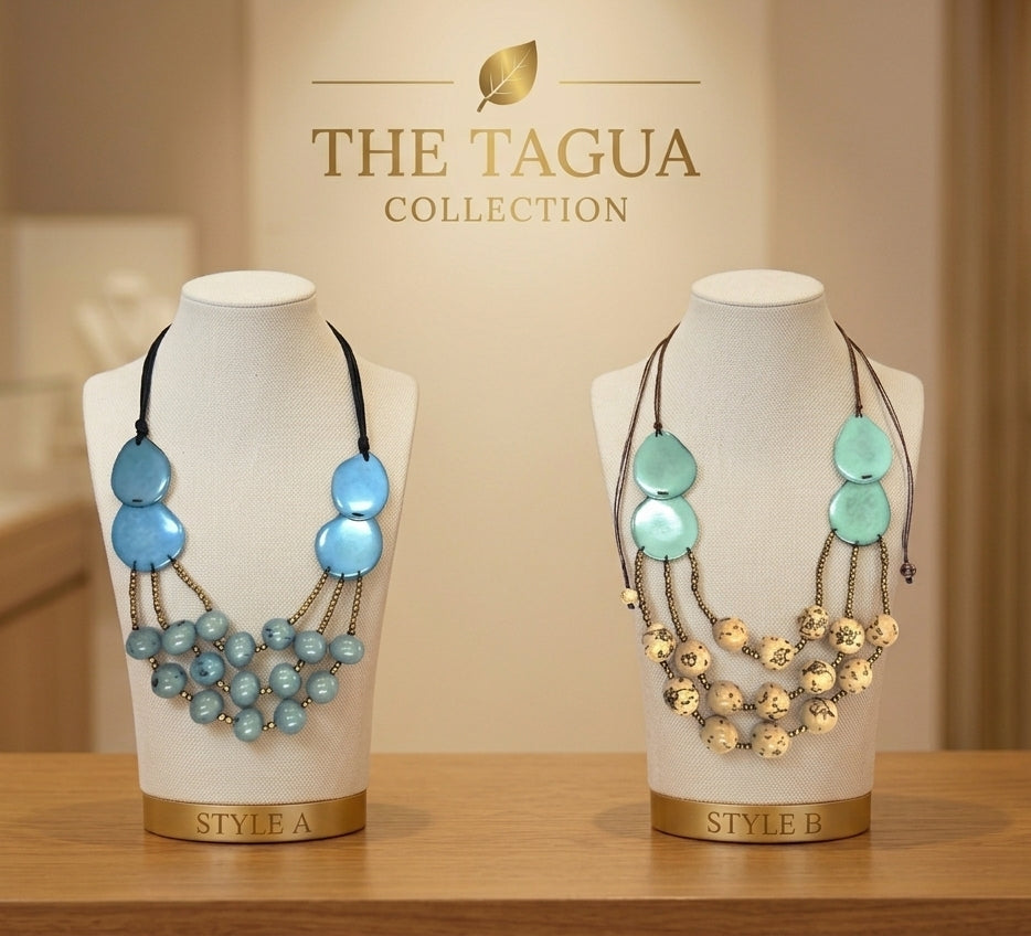 Two statement bib necklaces from The Tagua Collection displayed on white mannequin busts. The left necklace (Style A) features light blue oval beads, a black cord, and cascading light blue beads.