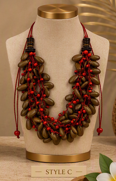 A multi-strand statement necklace displayed on a beige fabric mannequin bust with a gold base. The necklace features dark brown coconut shell beads strung on red cords with small red beads, and is labeled 'STYLE C' at the bottom.